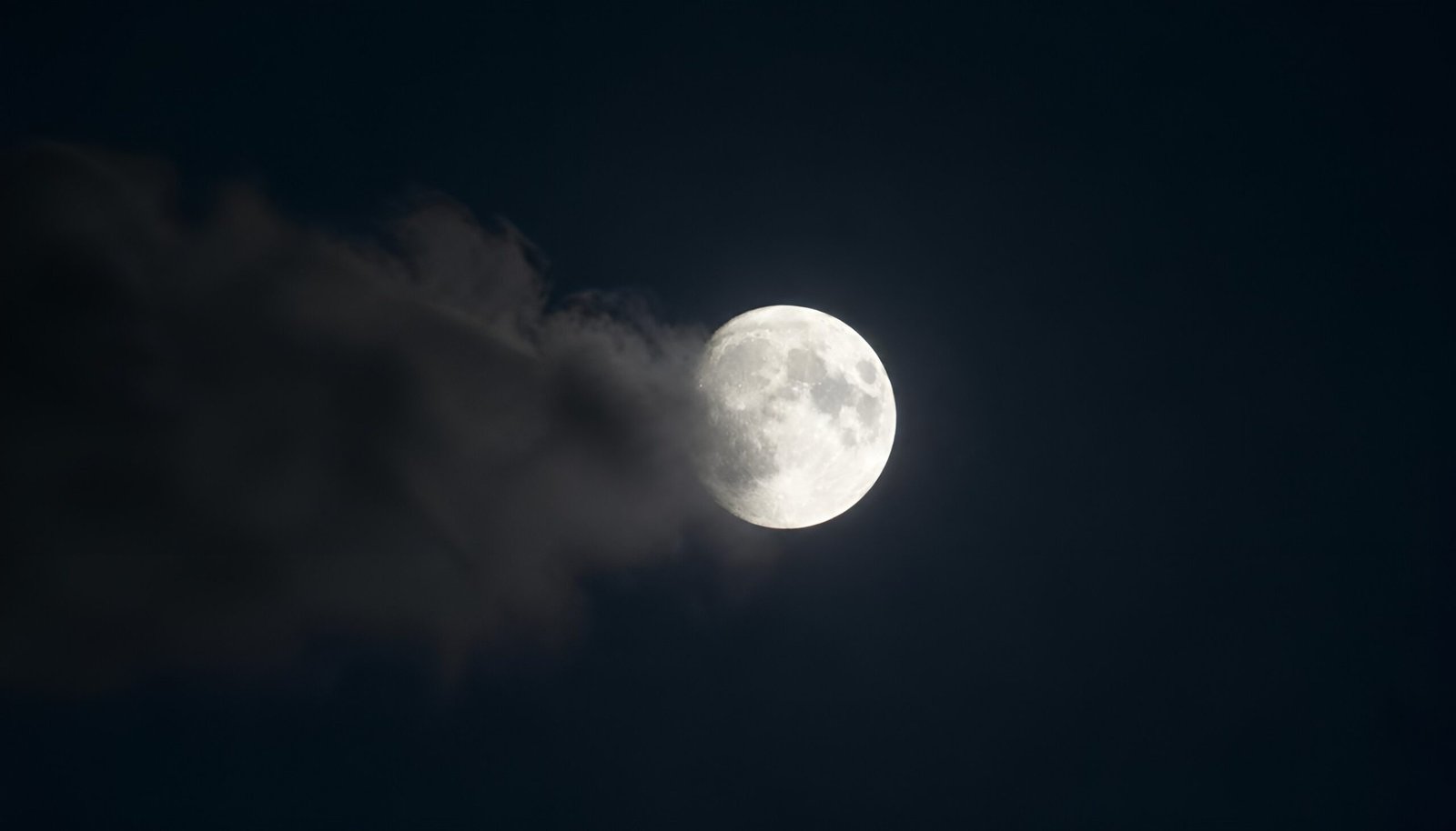 A moon emerging from behind a dissolving cloud - Buddha's teaching on redemption through the story of Angulimala